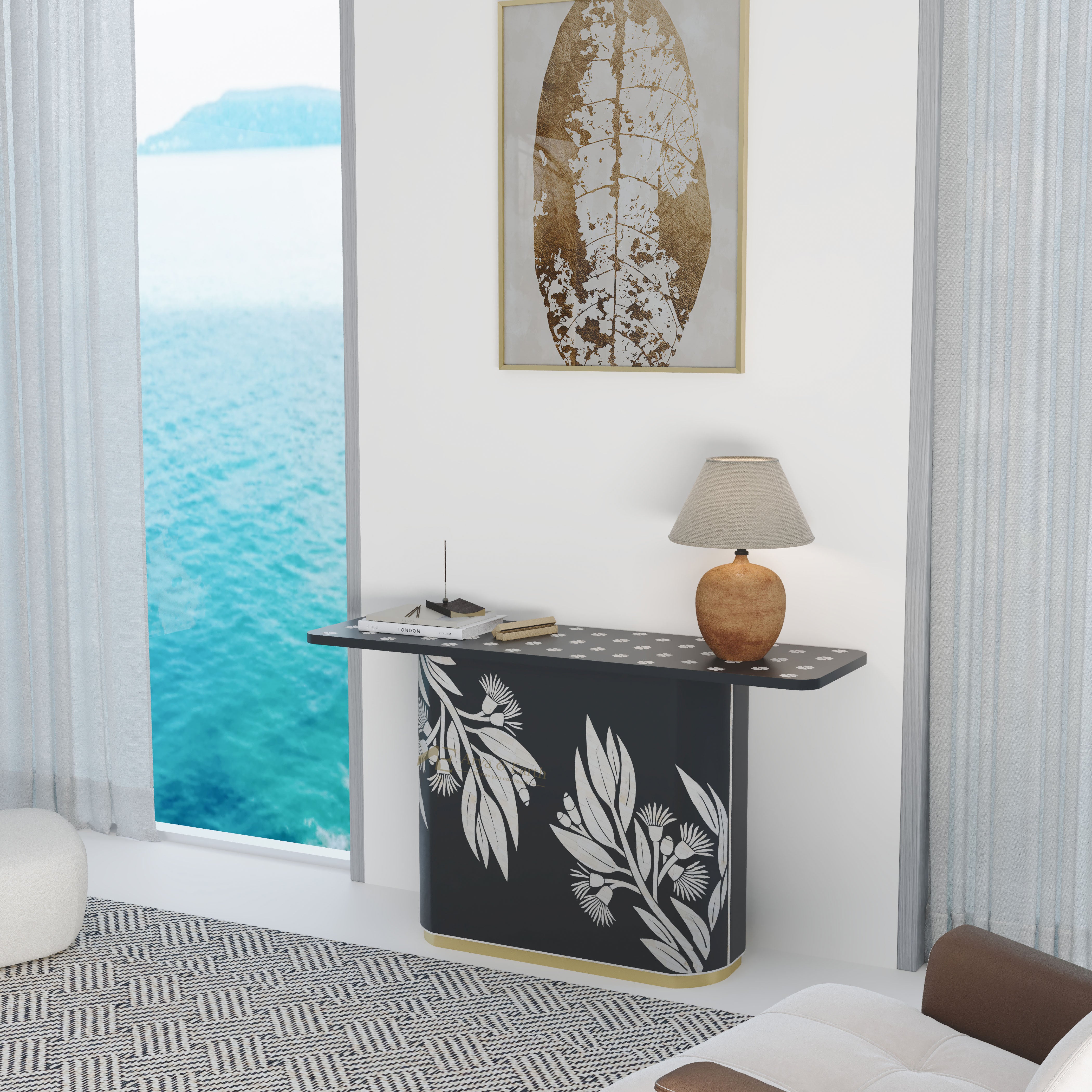 Modern interior with a black console table featuring white leaf patterns, a lamp, and a framed artwork by a large window with ocean view.