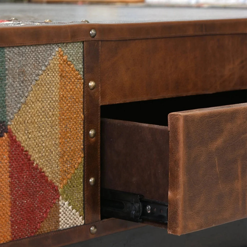 Close-up of a wooden drawer with geometric patterned side, blurred background