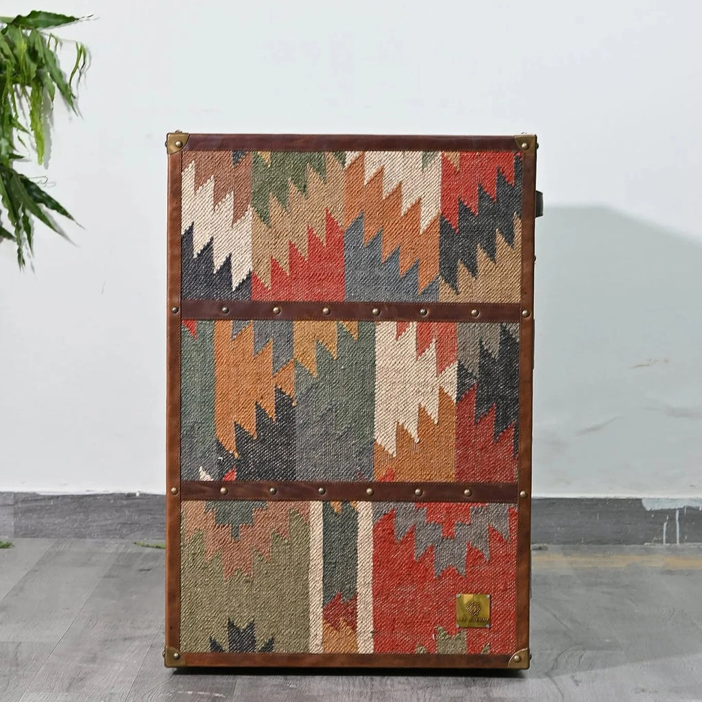 Vintage-style trunk with geometric pattern on a gray floor.