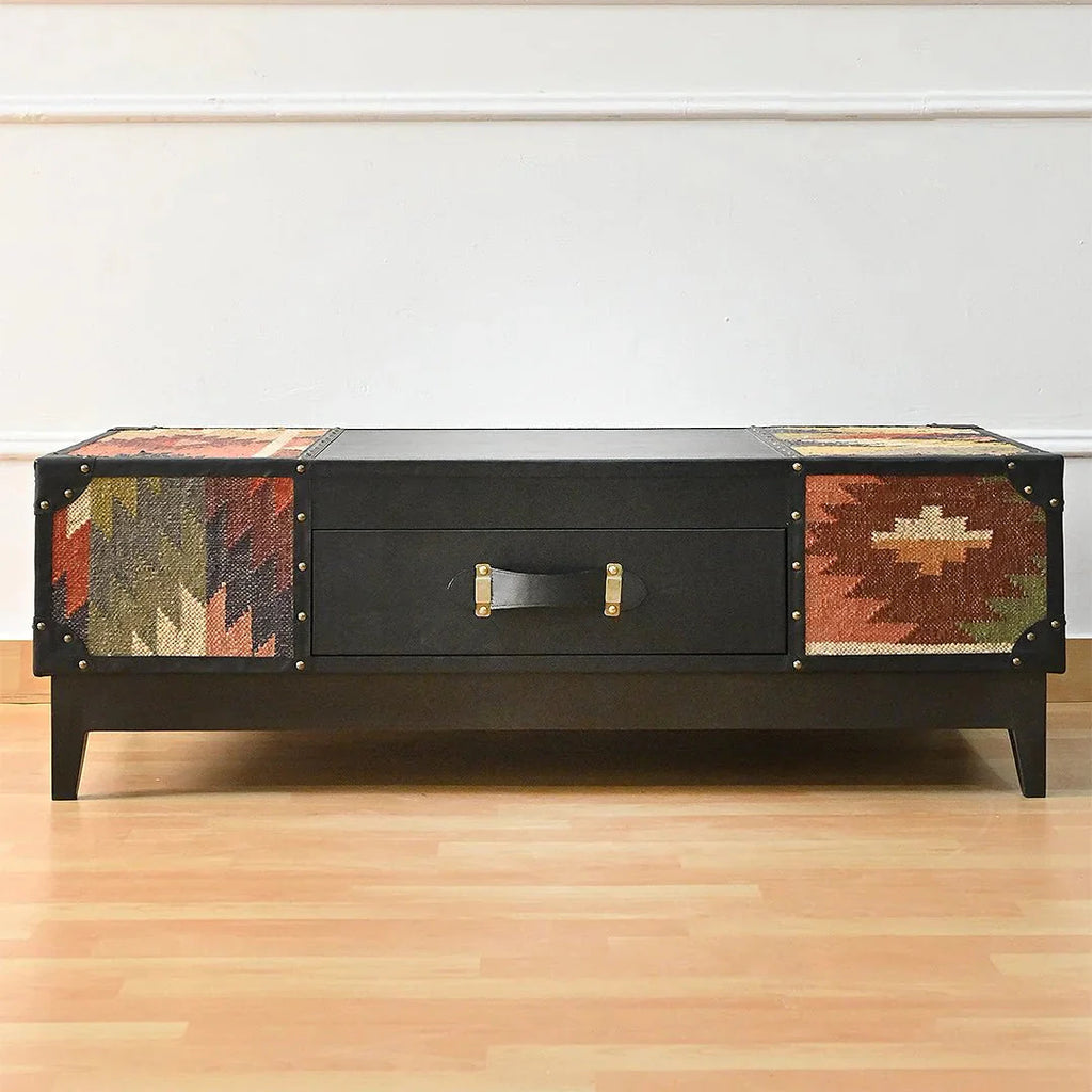 Black coffee table with patterned sides on a wooden floor