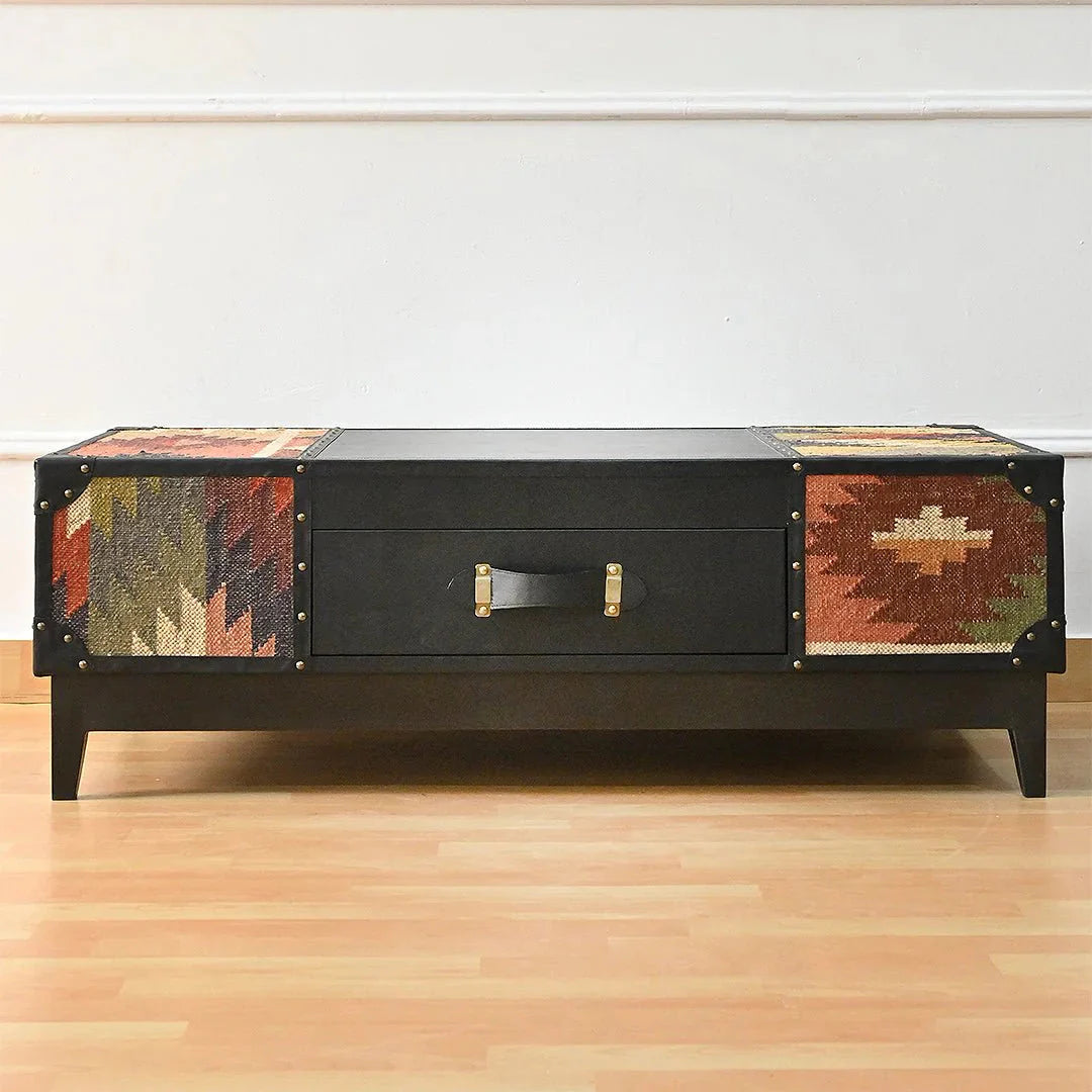 Black coffee table with patterned sides on a wooden floor