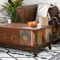 Brown leather sofa with a patterned coffee table, oranges, and a cup on a white wall background.