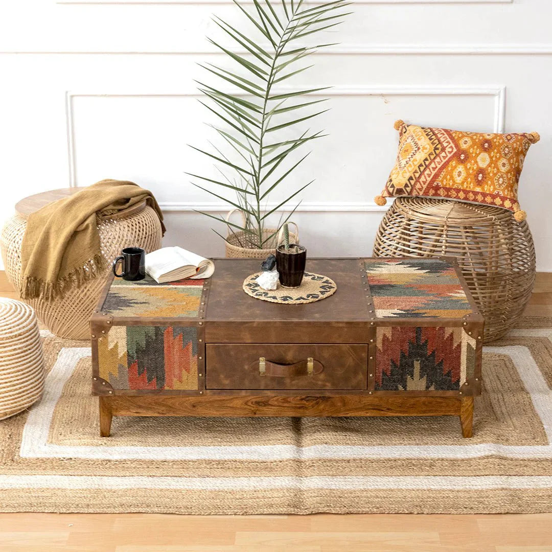 Living room with a wooden coffee table, wicker chairs, and decorative pillows.